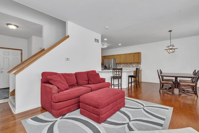 living room with a chandelier and light hardwood / wood-style flooring