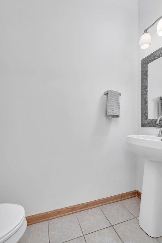 bathroom with tile patterned flooring, toilet, and sink