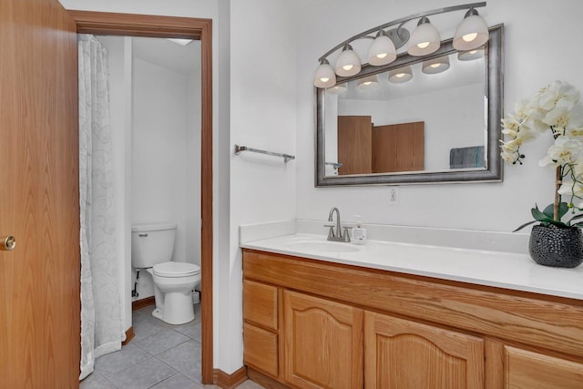 bathroom with toilet, vanity, and tile patterned floors