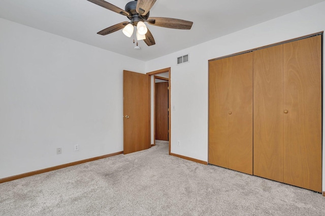 unfurnished bedroom with a closet, light colored carpet, and ceiling fan