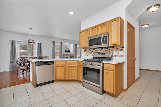 kitchen with a chandelier, decorative backsplash, stainless steel appliances, and a healthy amount of sunlight