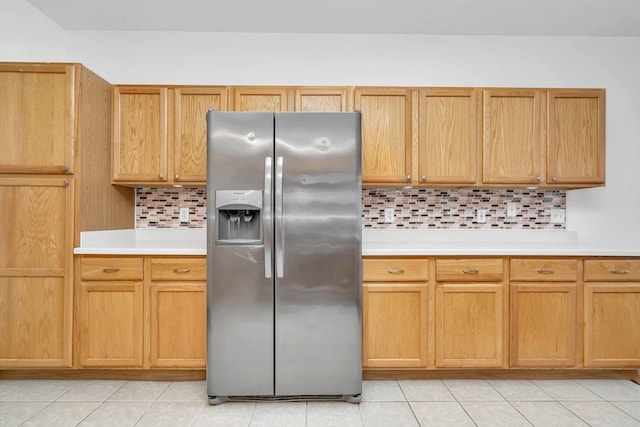 kitchen with backsplash, stainless steel fridge, and light tile patterned flooring