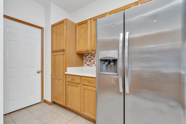 kitchen with light brown cabinets, stainless steel fridge with ice dispenser, light tile patterned floors, and tasteful backsplash