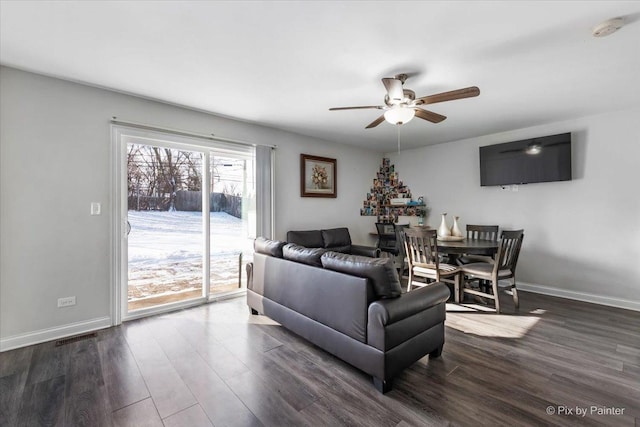 living room featuring ceiling fan and dark hardwood / wood-style flooring