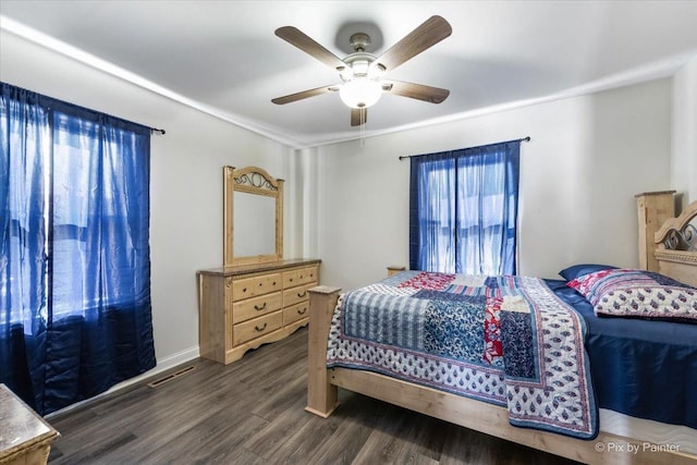 bedroom with multiple windows, dark hardwood / wood-style flooring, and ceiling fan