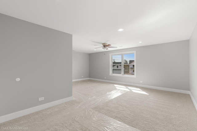 spare room featuring light colored carpet and ceiling fan