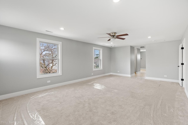 spare room featuring light colored carpet and ceiling fan