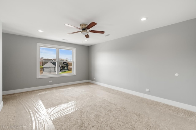 carpeted spare room featuring ceiling fan