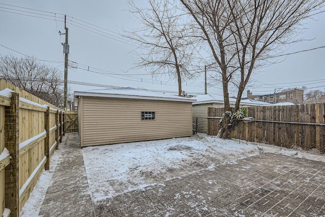 snow covered patio featuring an outbuilding