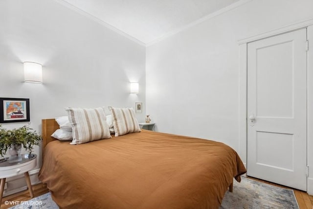 bedroom featuring crown molding and light hardwood / wood-style flooring