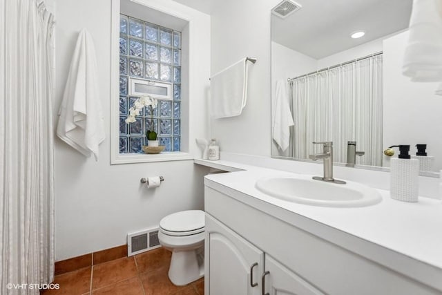 bathroom featuring tile patterned flooring, vanity, and toilet