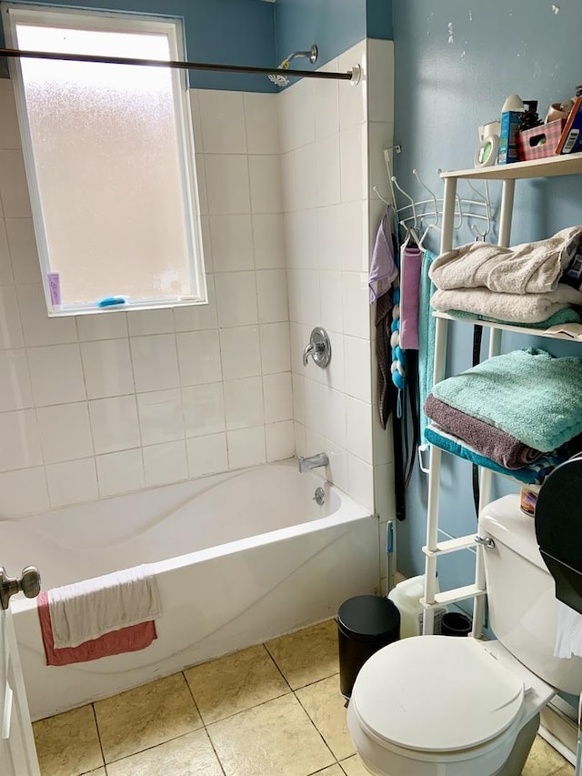 bathroom featuring tile patterned floors, toilet, and tiled shower / bath