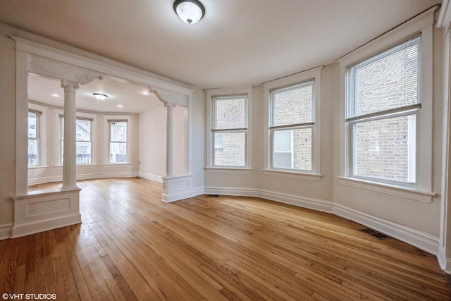 unfurnished sunroom with ornate columns and a healthy amount of sunlight