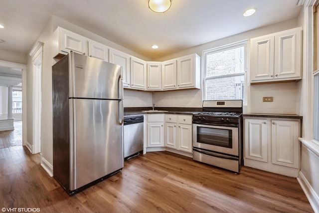 kitchen featuring white cabinets, stainless steel appliances, plenty of natural light, and sink