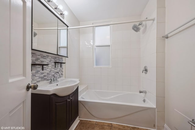 bathroom featuring tile patterned floors, vanity, tiled shower / bath, and tasteful backsplash