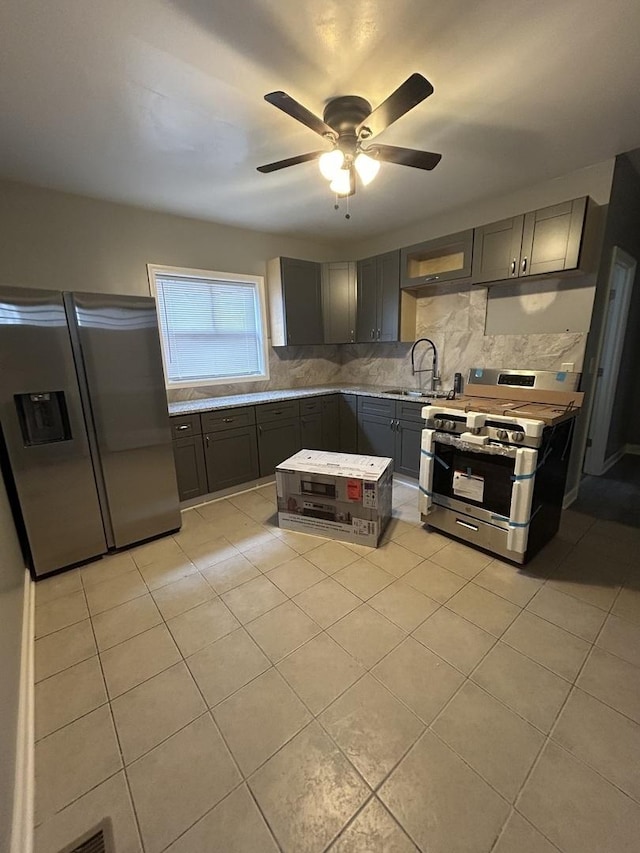 kitchen featuring ceiling fan, sink, stainless steel appliances, tasteful backsplash, and light tile patterned flooring