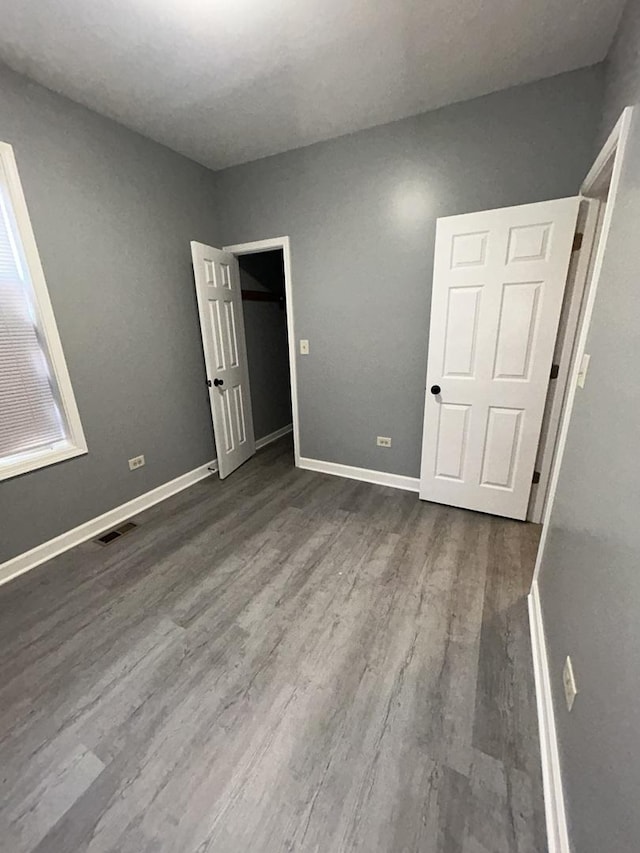 unfurnished bedroom with dark hardwood / wood-style flooring