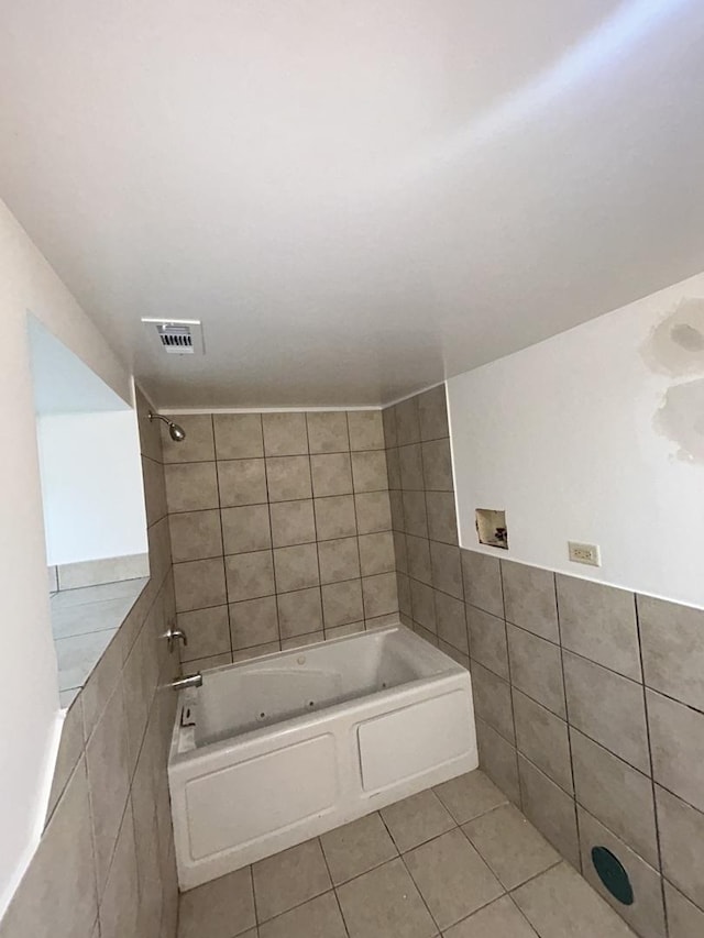 bathroom with tile patterned flooring, tiled shower / bath combo, and tile walls