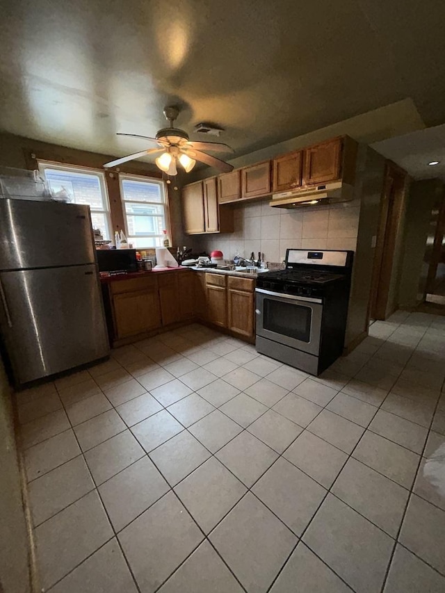 kitchen featuring backsplash, stainless steel appliances, ceiling fan, sink, and light tile patterned floors