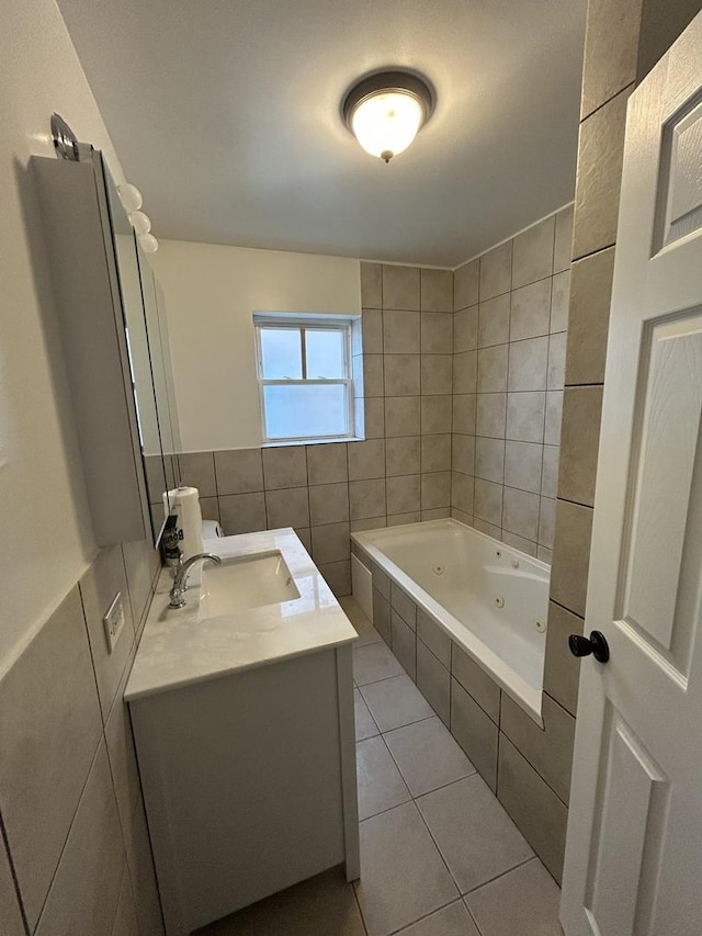 bathroom featuring tile patterned floors, vanity, tile walls, and tiled bath