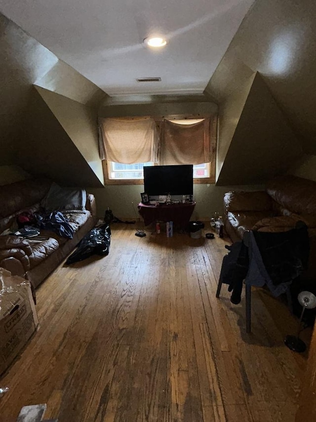 additional living space with hardwood / wood-style floors and vaulted ceiling