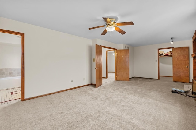 interior space with ceiling fan and light colored carpet