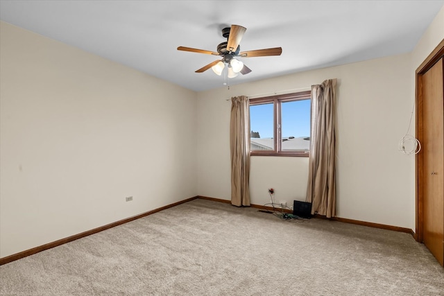 carpeted spare room with ceiling fan