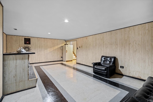 unfurnished living room with wood walls