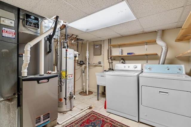 laundry room with water heater, heating unit, washing machine and clothes dryer, and sink