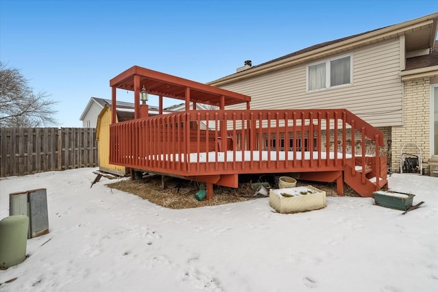 snow covered back of property featuring a deck