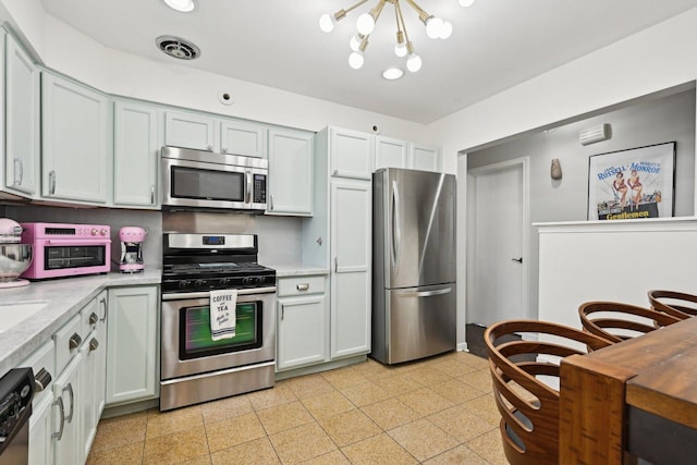 kitchen with an inviting chandelier and stainless steel appliances