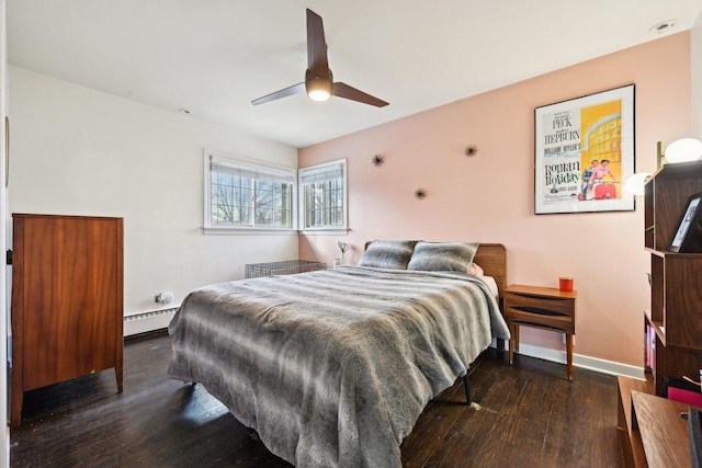 bedroom featuring dark wood-type flooring, ceiling fan, and baseboard heating