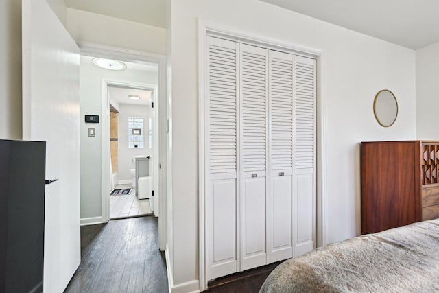 bedroom with dark hardwood / wood-style floors and a closet