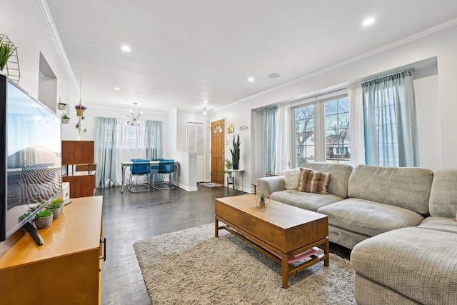 living room featuring ornamental molding, dark hardwood / wood-style floors, and a chandelier