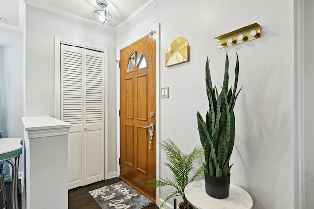 foyer with dark wood-type flooring and ornamental molding