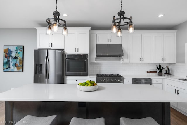 kitchen with decorative light fixtures, a kitchen island, and appliances with stainless steel finishes