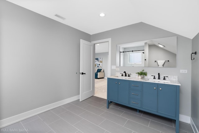 bathroom with tile patterned flooring, vanity, and vaulted ceiling