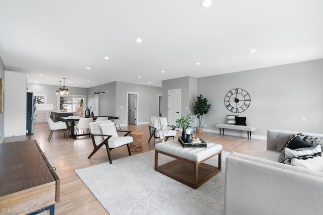 living room with a chandelier and light hardwood / wood-style floors