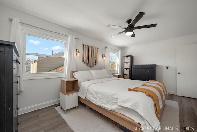 bedroom with dark hardwood / wood-style floors and ceiling fan