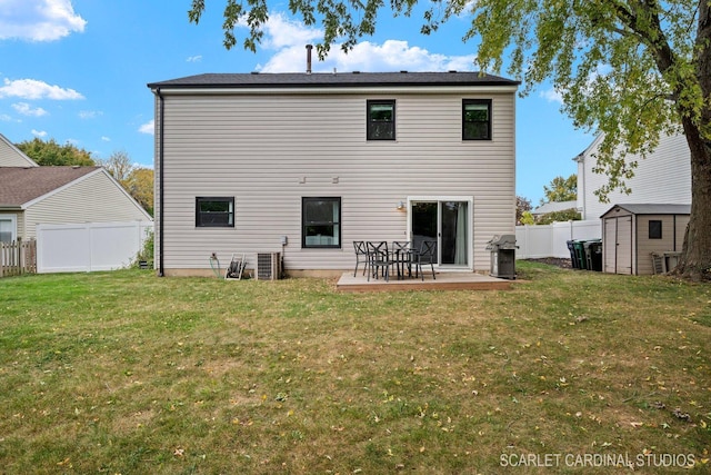 back of house featuring a storage shed, a yard, and a patio area