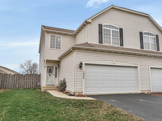 view of property featuring a garage and a front lawn