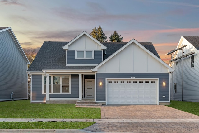 view of front of home with a garage and a lawn