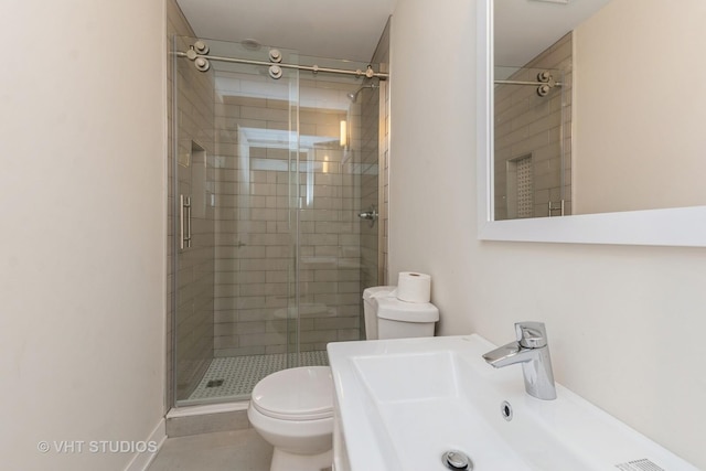 bathroom with sink, a shower with shower door, and toilet