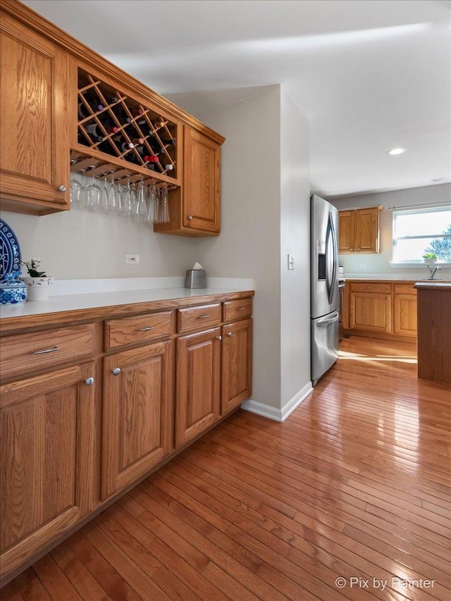 kitchen with stainless steel fridge and light hardwood / wood-style floors