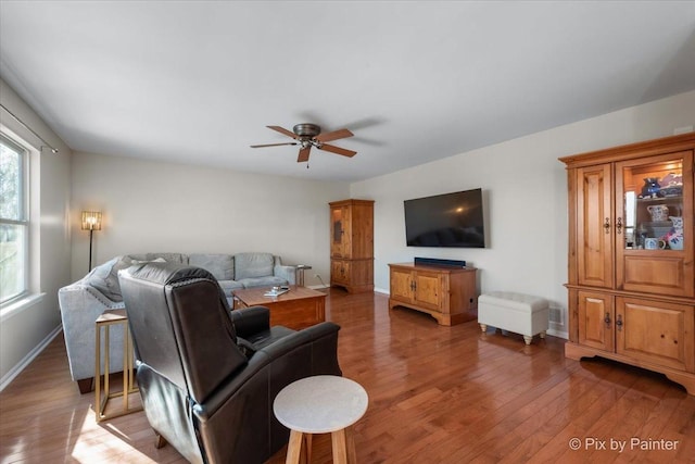 living room with dark wood-type flooring and ceiling fan