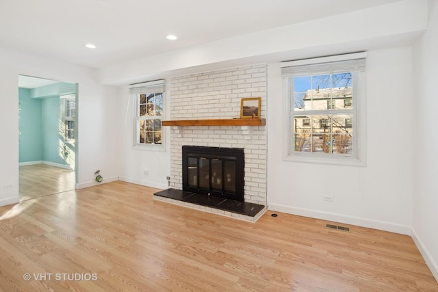 unfurnished living room featuring a fireplace and light hardwood / wood-style flooring