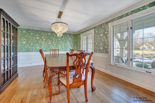 dining room with a notable chandelier, crown molding, and light hardwood / wood-style floors