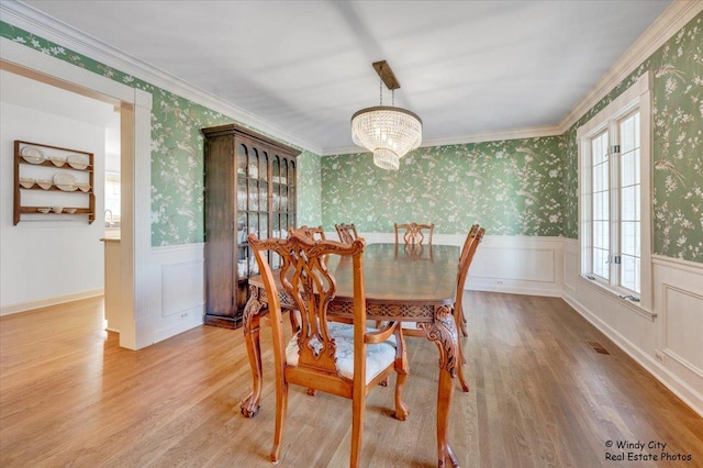 dining room featuring plenty of natural light, ornamental molding, and light wood-type flooring