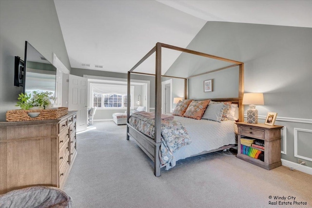 carpeted bedroom with lofted ceiling