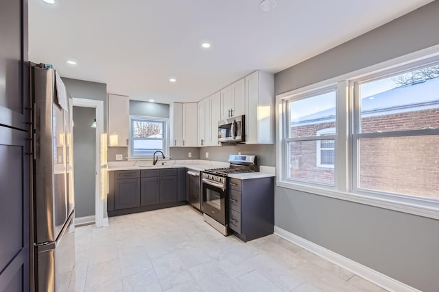 kitchen featuring appliances with stainless steel finishes, gray cabinetry, white cabinets, and sink